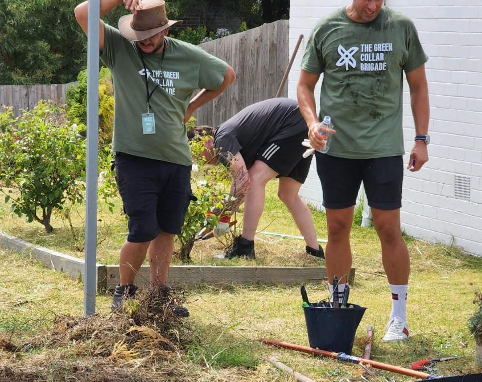Brigade crew clearing weeds in their green tees