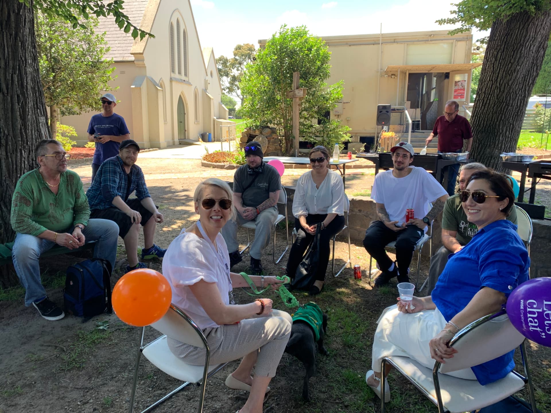 Brigade members and Wise Employment staff sitting in a yarn circle at a community BBQ