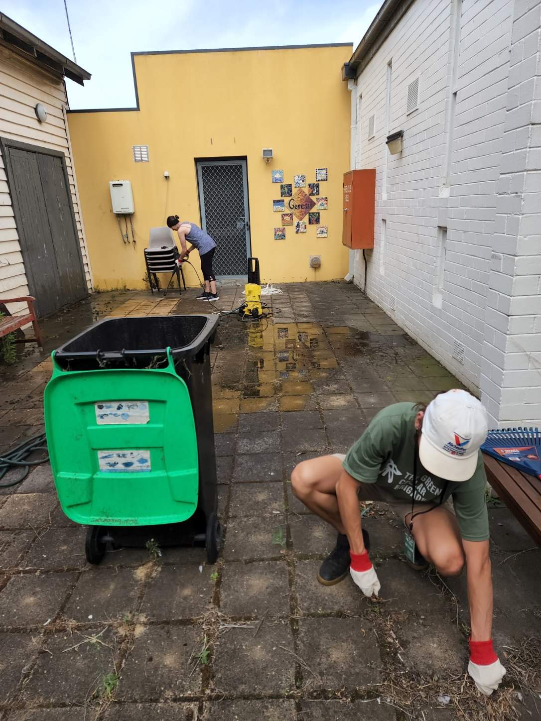 Brigade volunteers pressure-washing a community hall courtyard