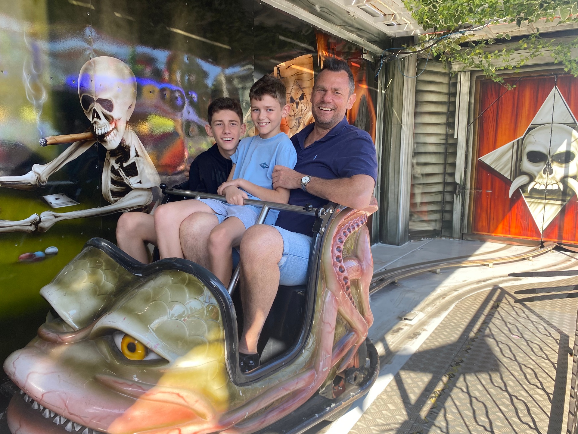 Stu with his two boys on a fairground rollercoaster — laughs all round